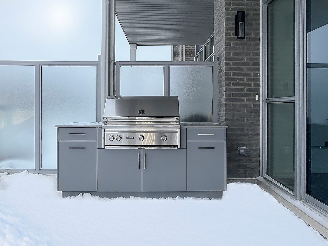 Outdoor grill in cabinetry with snow on ground in winter