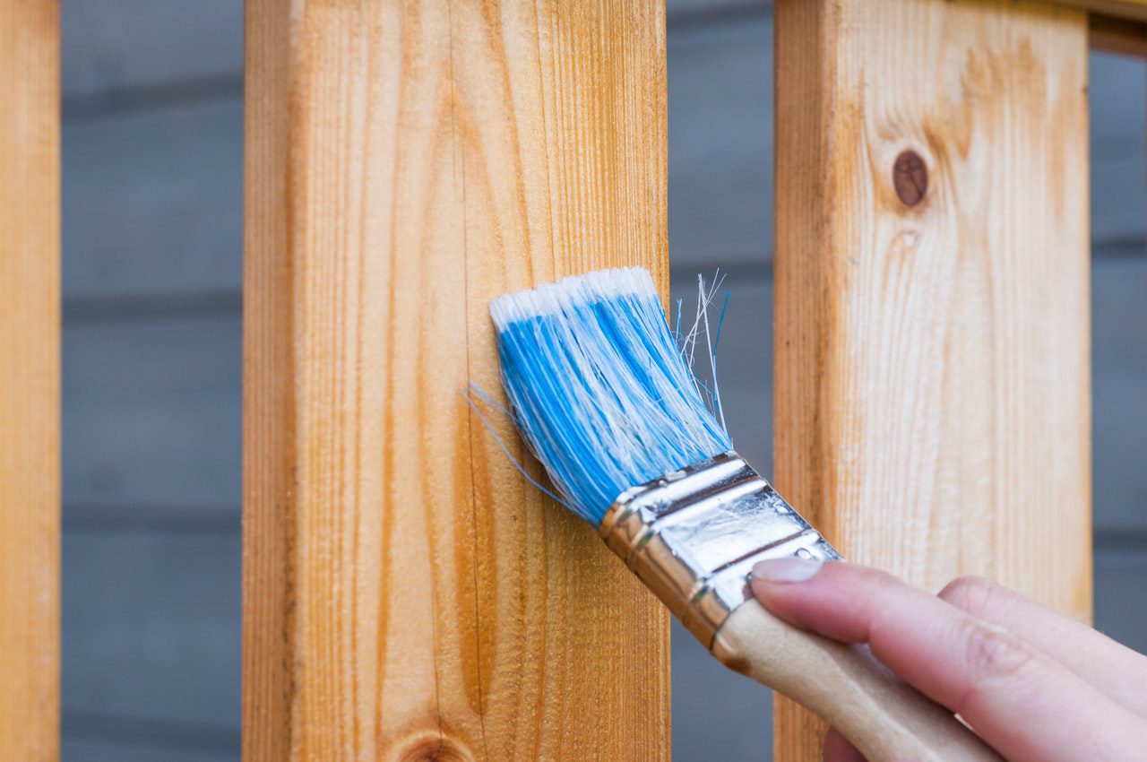 person staining fence