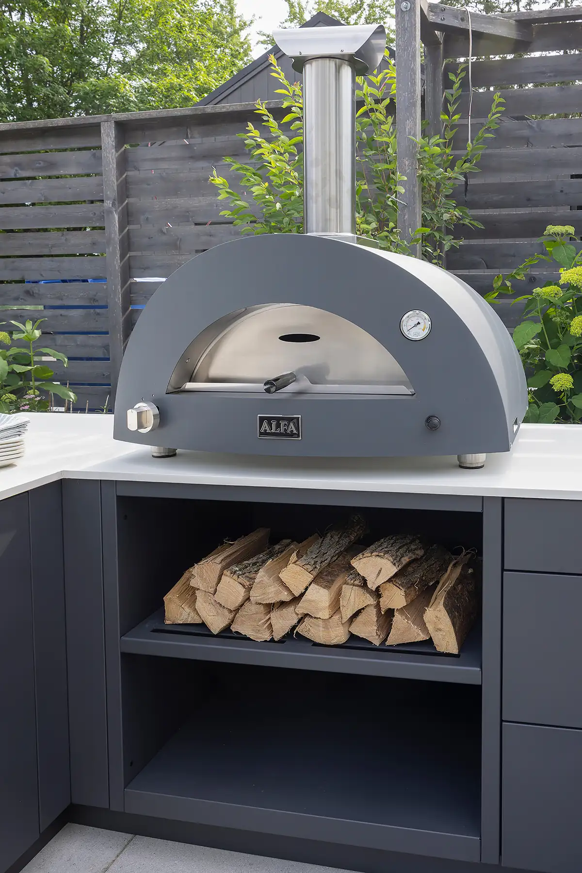 Modern covered terrace outdoor kitchen featuring flush limestone cabinetry wine bottle and glasses