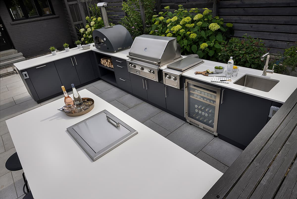 Covered stone terrace outdoor kitchen with built in charcoal grill and flush Alumina cabinets