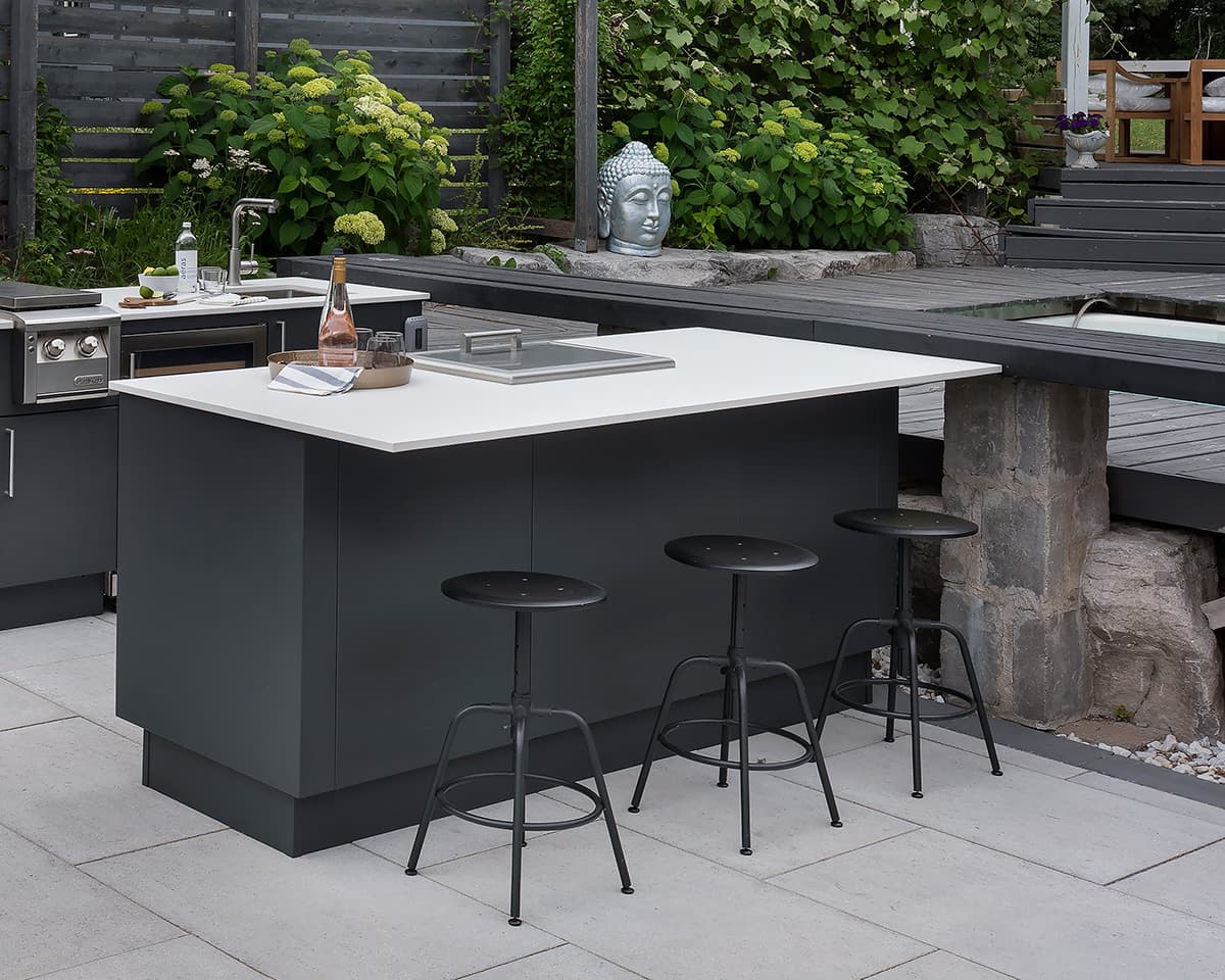 Modern covered terrace outdoor kitchen featuring flush limestone cabinetry wine bottle and glasses