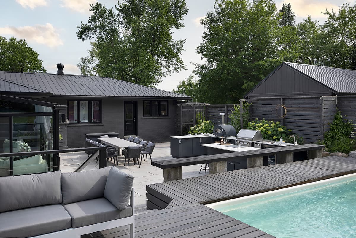 Modern outdoor kitchen with built in Alfresco grill and Alumina cabinetry on a covered terrace
