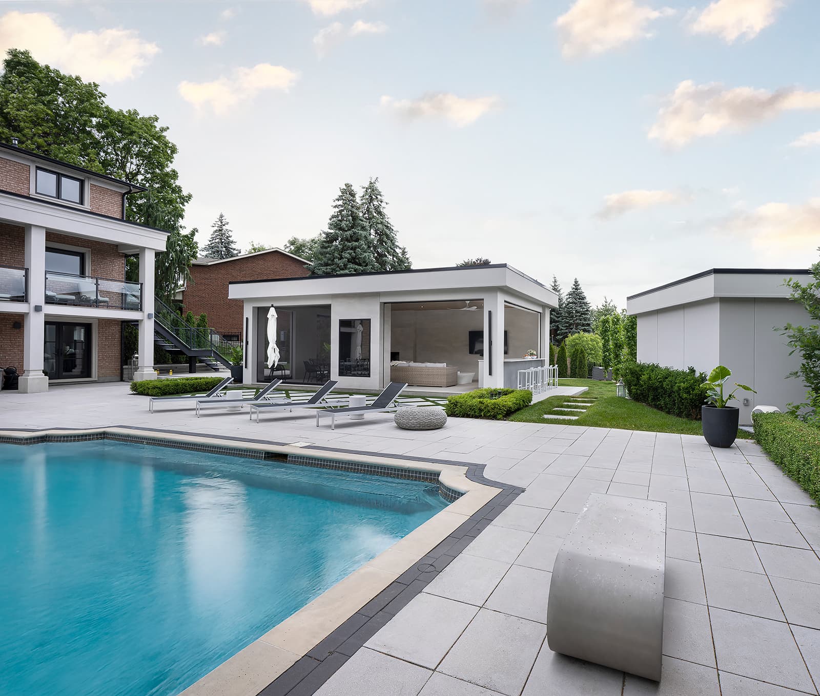 wide shot of backyard with pool, cabana, and servery
