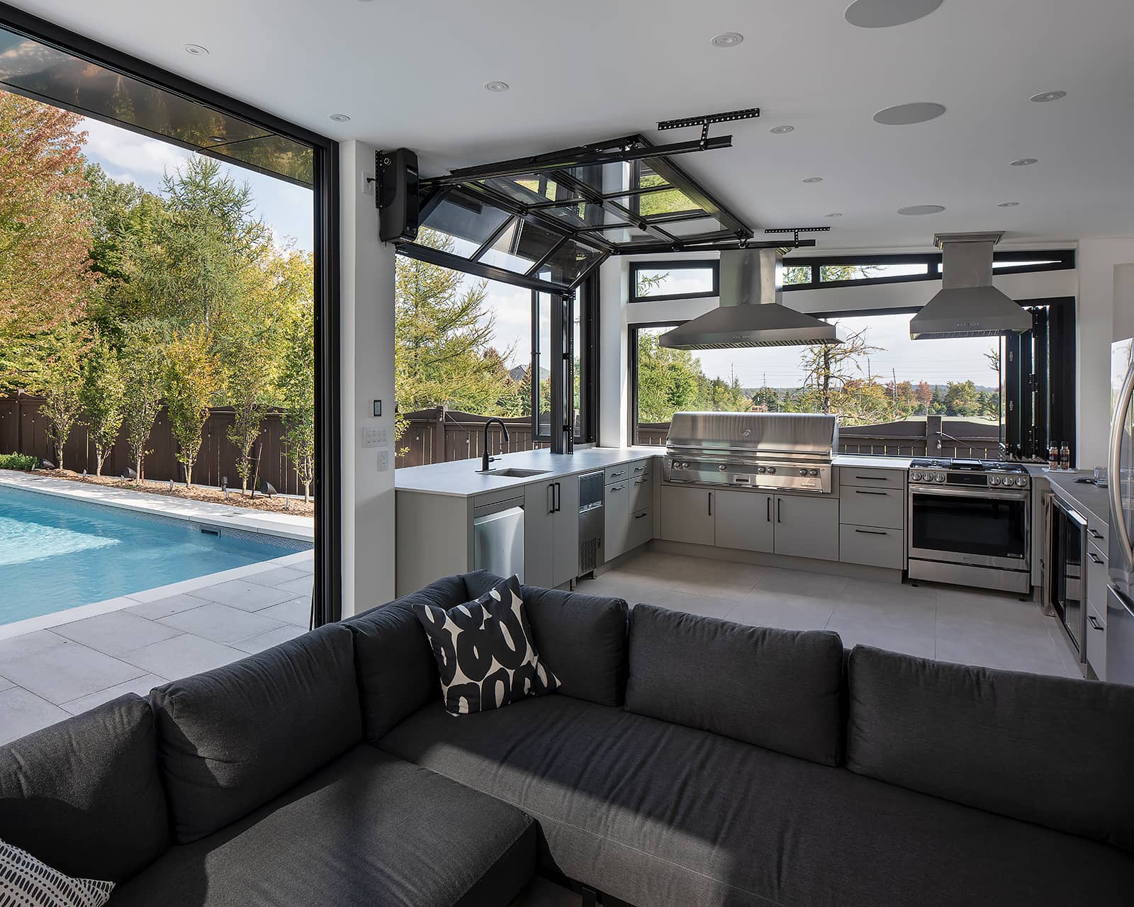 Poolside cabana kitchen in Toronto with an Alfresco ALXE-56 built-in gas grill, dishwasher, bar fridge and integrated sink area