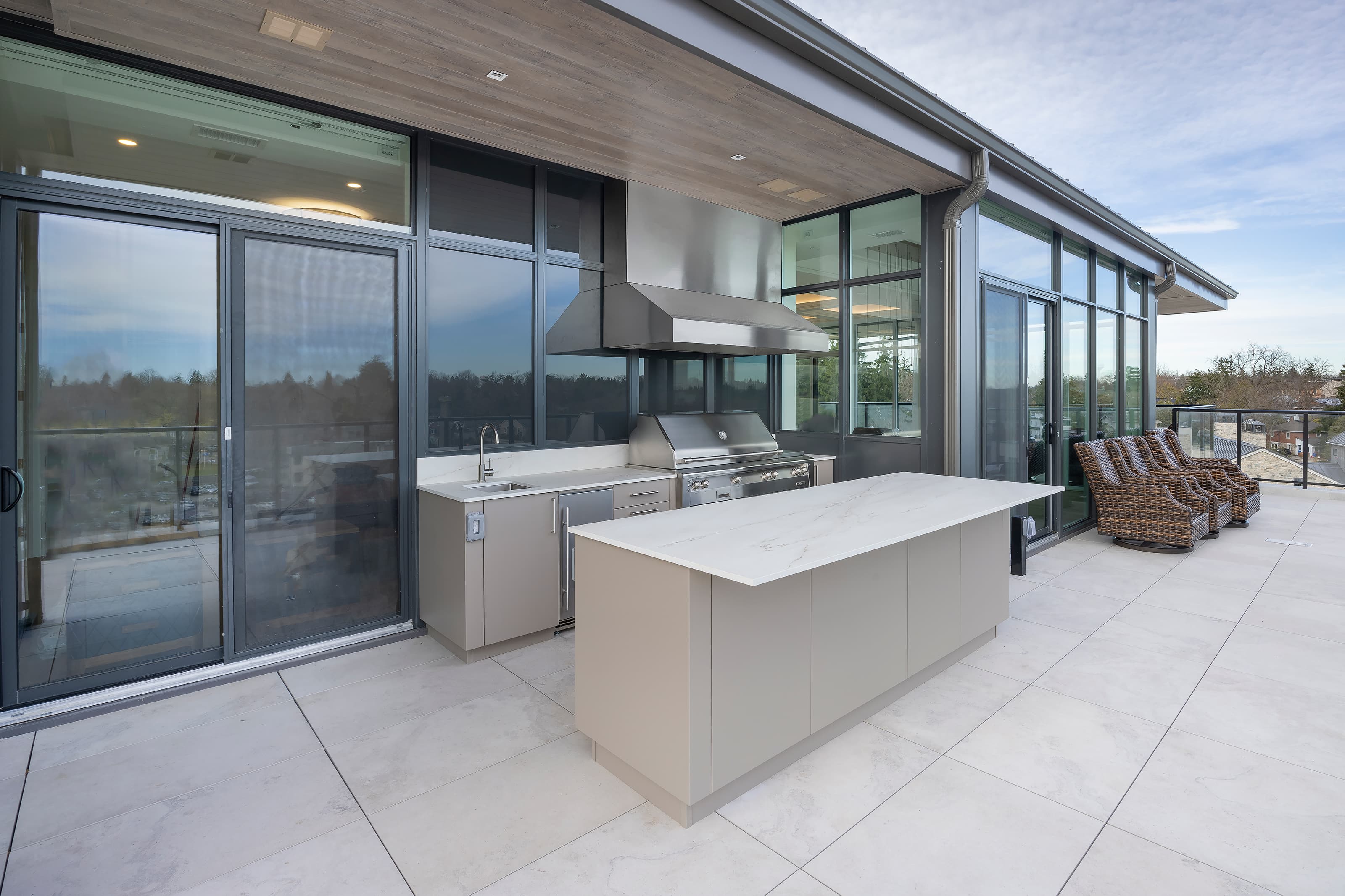 modern penthouse outdoor kitchen angled view, large glass doors and windows and large floor tiles