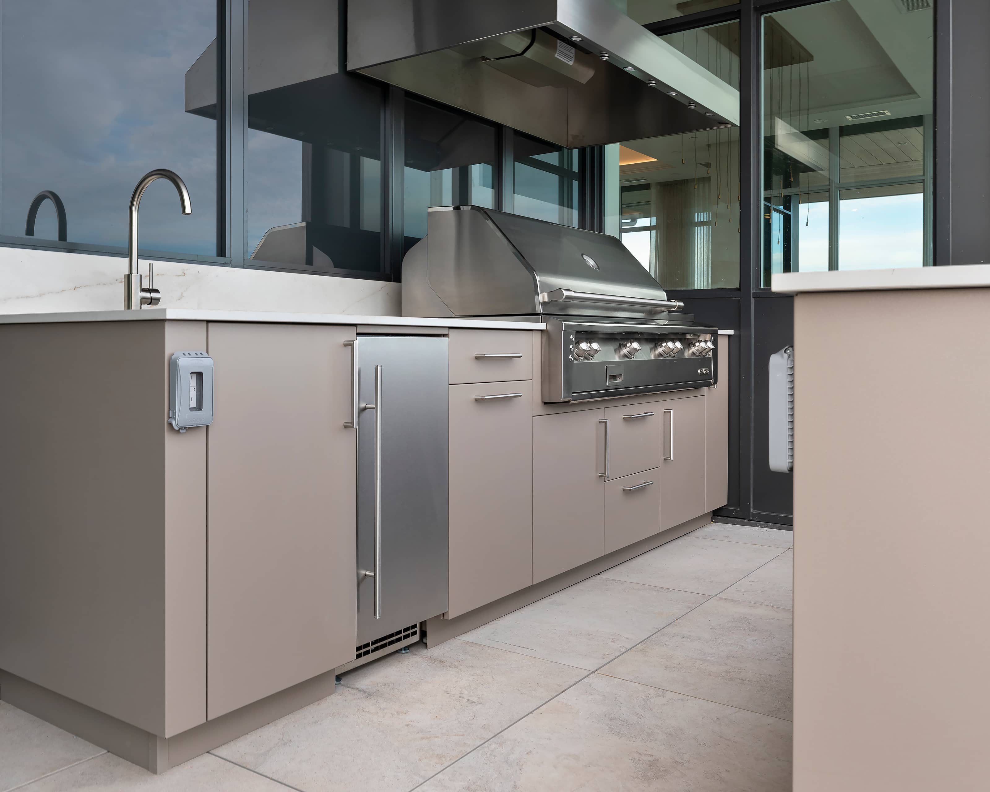 closeup view of sink, fridge, grill, and range hood.