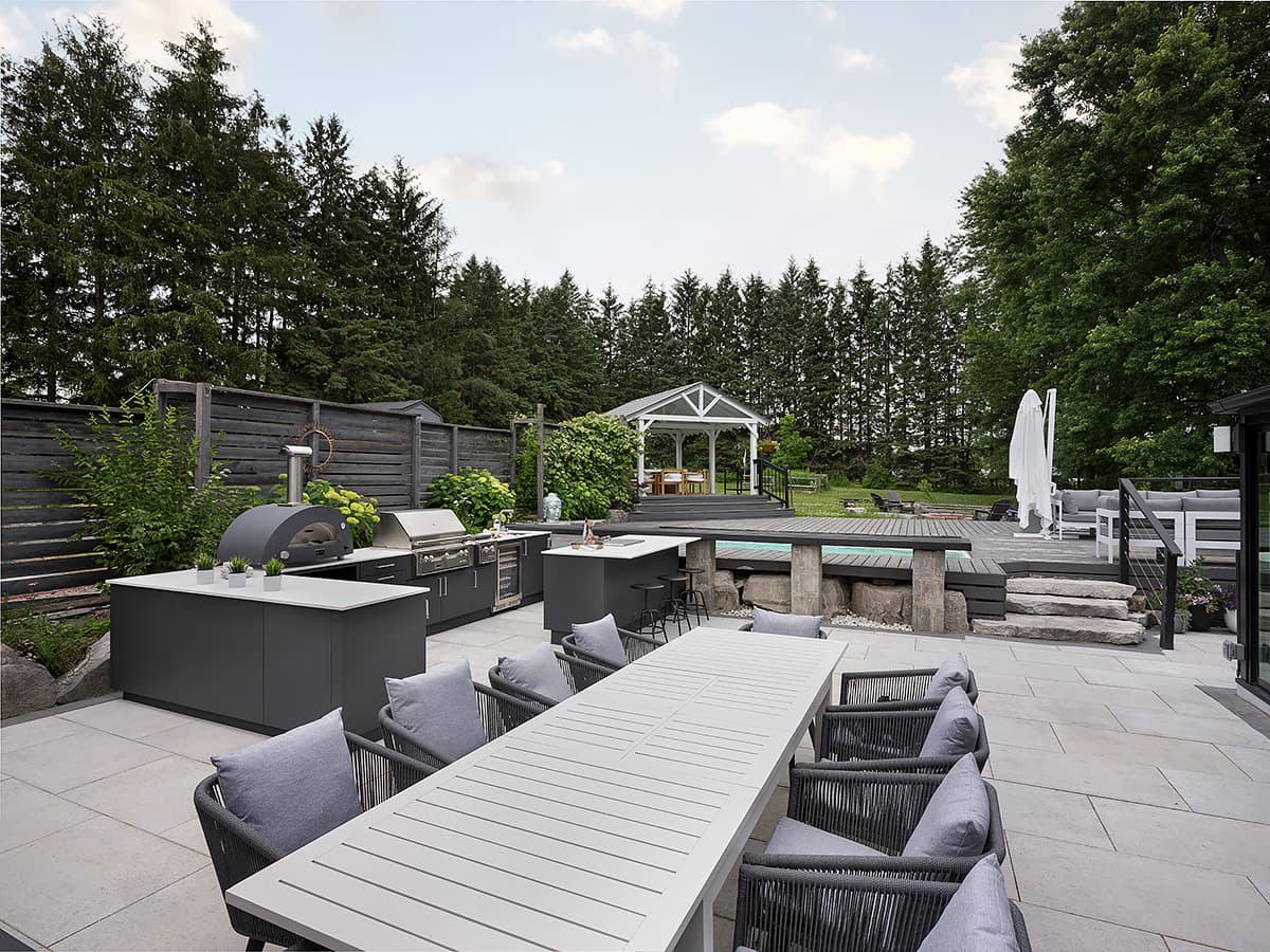 Modern outdoor kitchen with built in Alfresco grill and Alumina cabinetry on a covered terrace