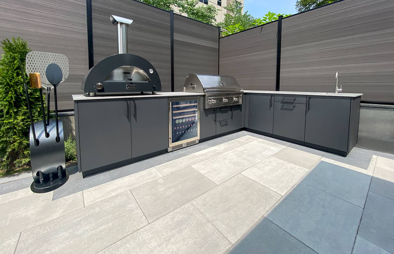 wide angle photo of cabinetry, pizza oven, grill, and sink