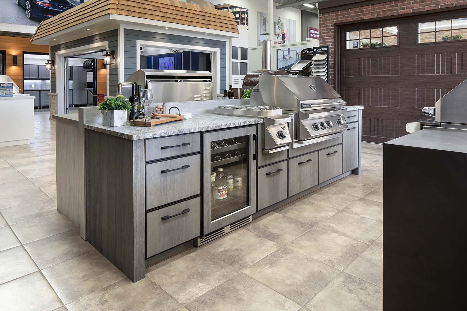bar fridge, warming grill and bbq grill in grey cabinetry displayed in Outeriors showroom