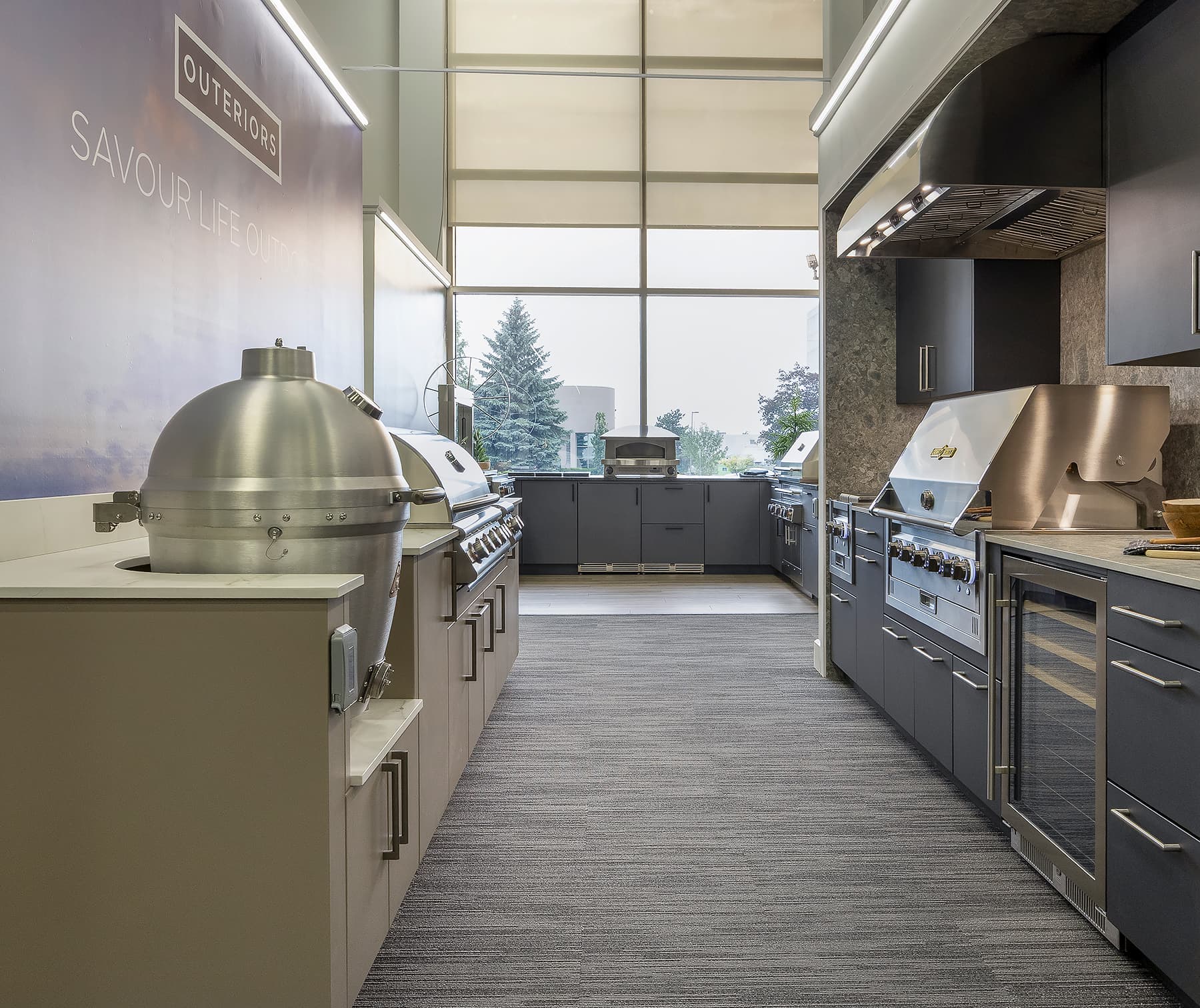 two outdoor kitchen displays facing each other with pizza ovenn in distance