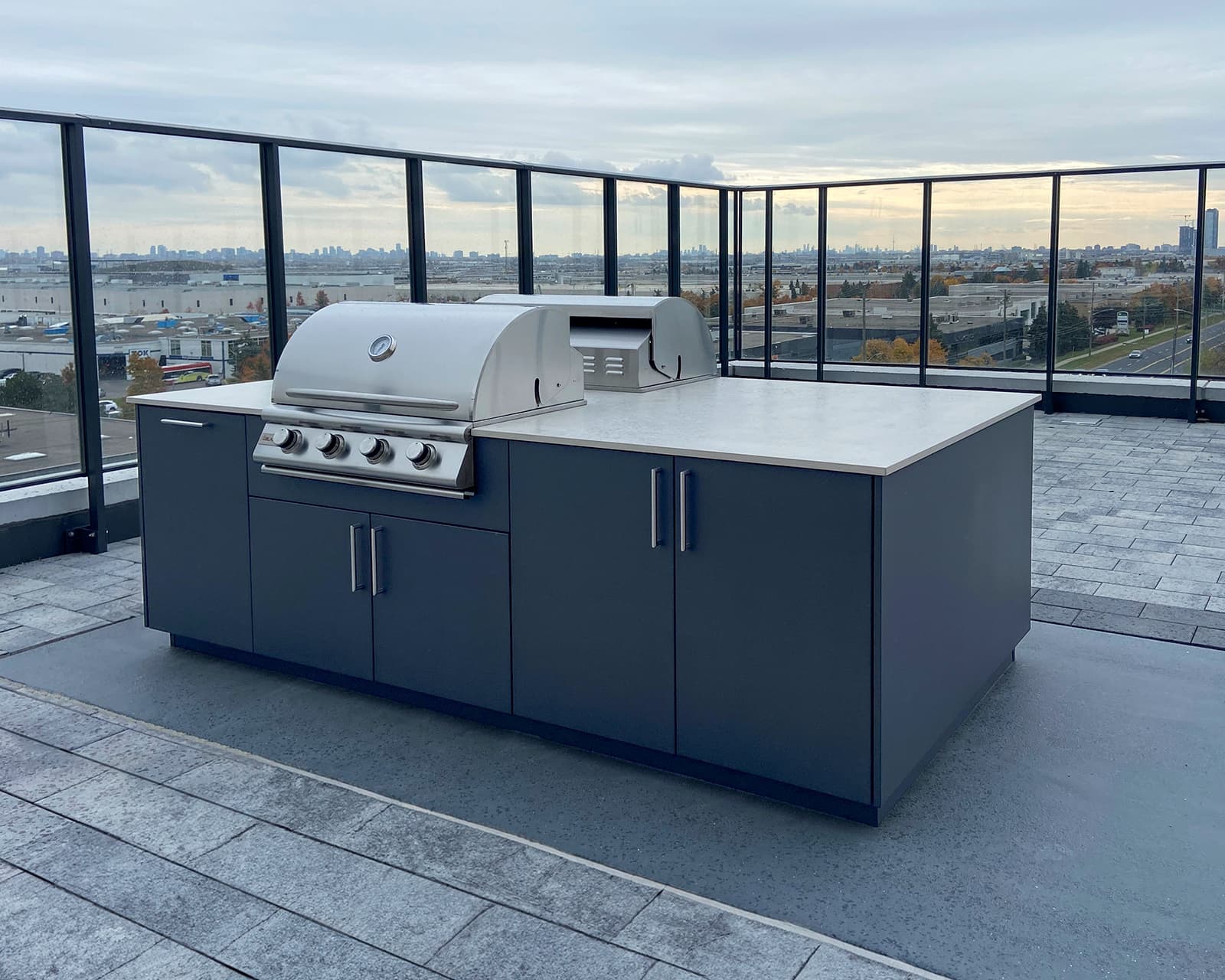 blue outdoor kitchen cabinets two grills rooftop glass railing