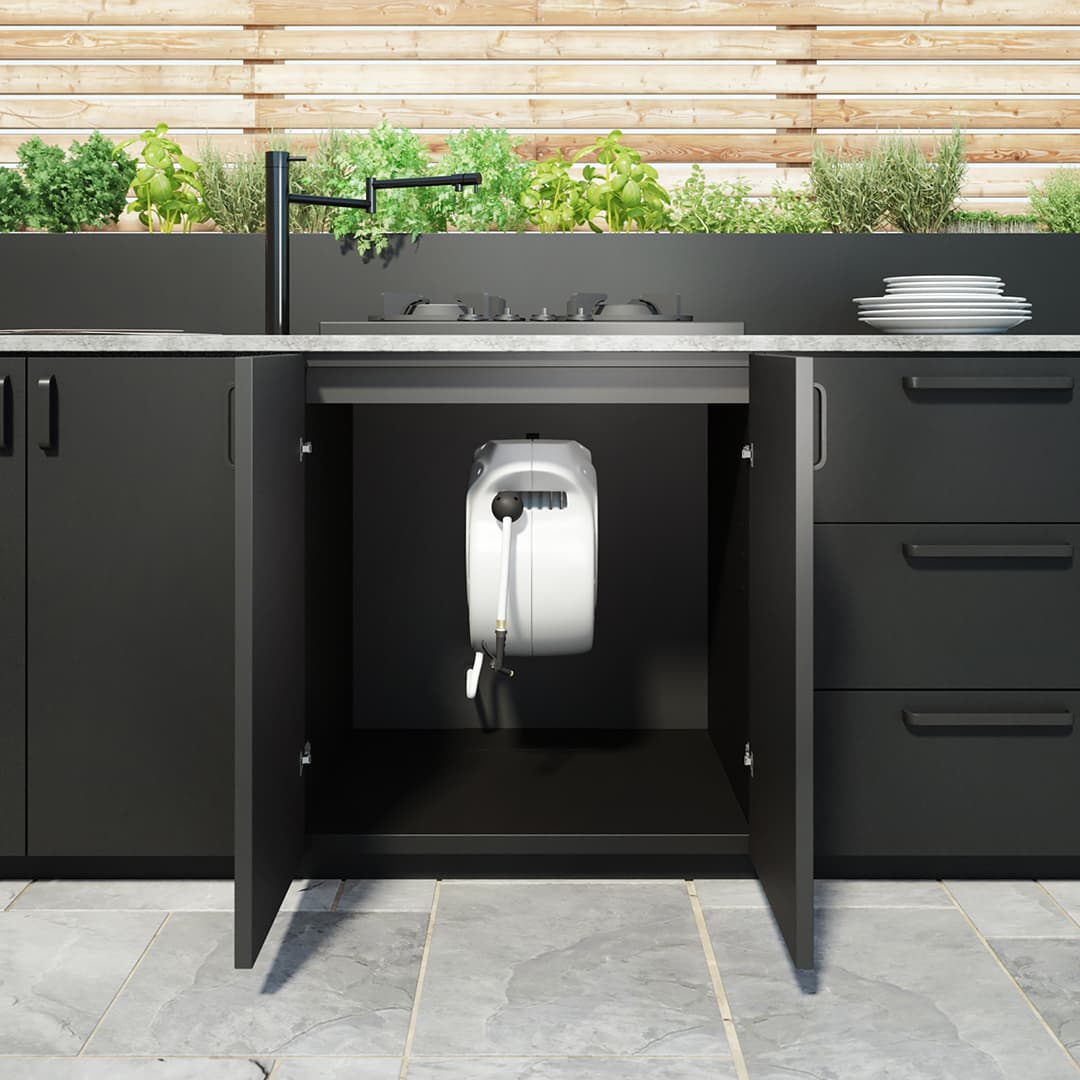 Retractable garden hose in dark outdoor kitchen cabinetry